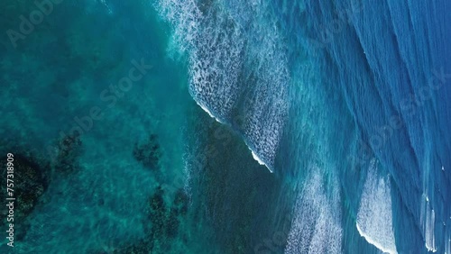 Aerial Drone flying over the Caribbean Barrier Reef in Dominican Republic. Waves crashing on coral. Shades of Blue. Vertical video. photo