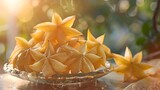A plate of star fruit is on a table. The fruit is yellow and has a star shape