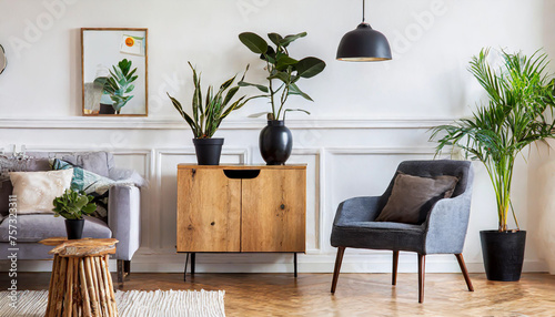 Modern scandinavian home interior with design wooden commode, plants in black pots, gray sofa, books and personal accessories. Stylish home decor. Template. Copy space. White walls © netsay