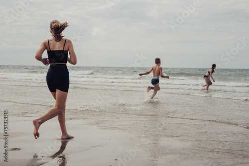 Kinder rennen vom Strand in das Meer (Domburg, Zeeland, Niederlande)