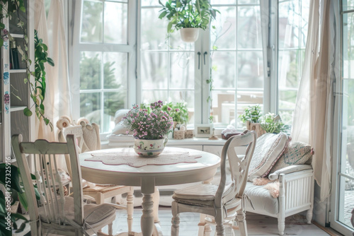 Rustic, vintage furniture, table and chairs in beige color in the dining room with large windows. © pilipphoto