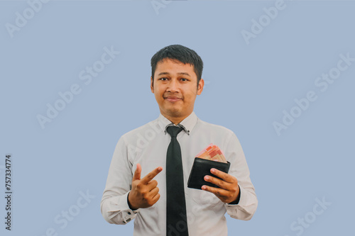 Adult Asian man smiling confident while pointing to wallet full of money that he hold photo