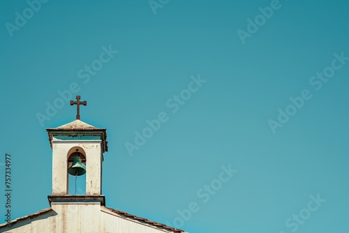 A photo of the top part of a church bell tower with a cross on it, against a clear blue sky background, in a minimalist, close-up shot Generative AI