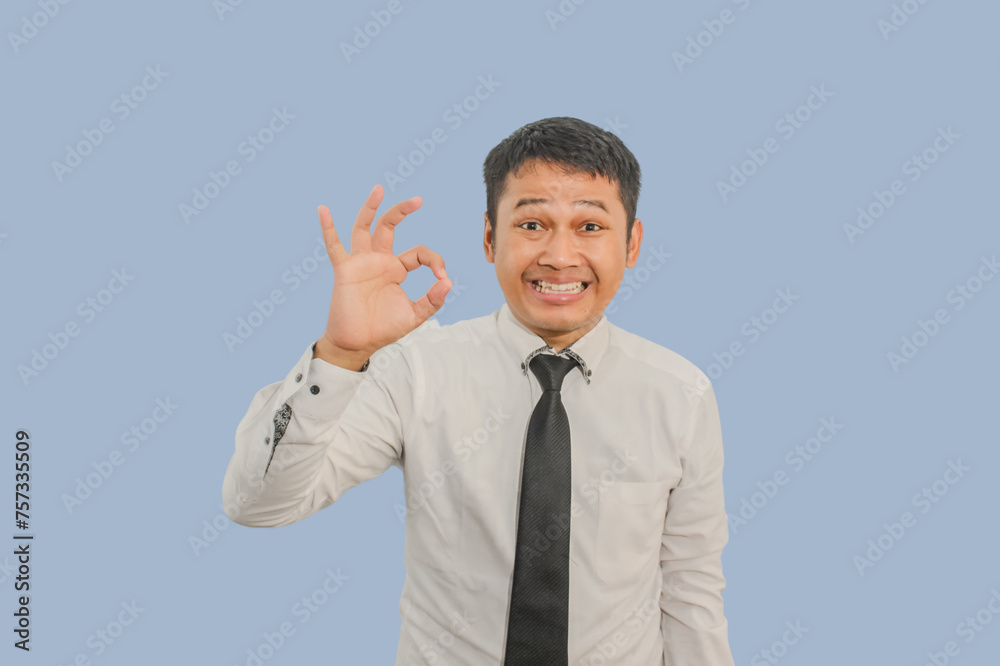 Adult Asian man smiling friendly and giving Adult Asian man smiling friendly and giving