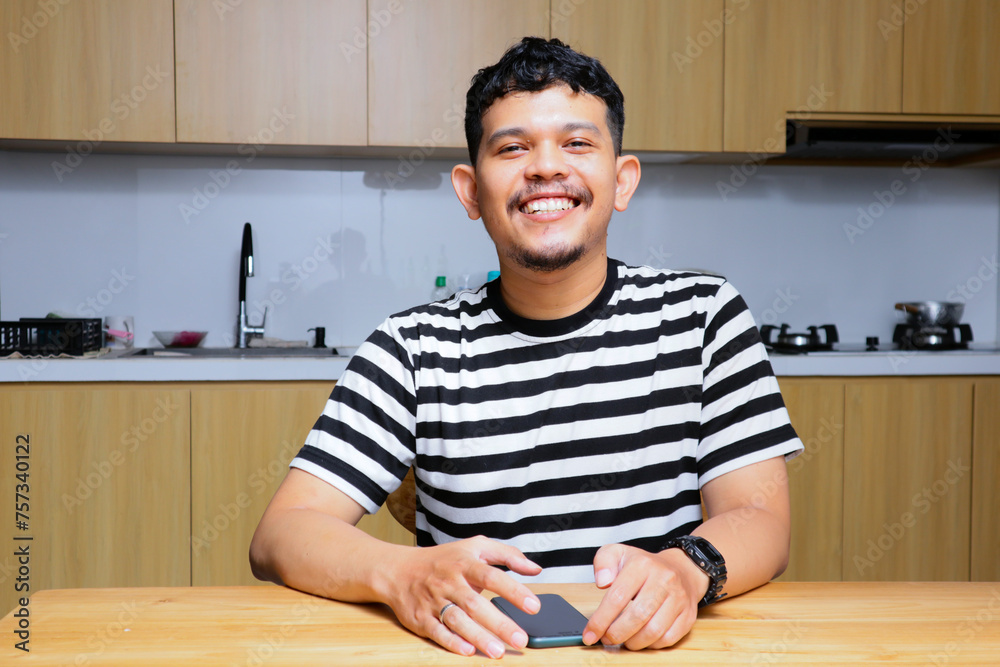 asian man smiling at the kitchen asian man smiling at the kitchen