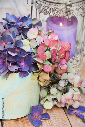 Vintage bouquet of hydrangeas with candle on wooden background