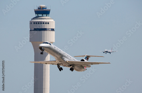 Commercial Airliners Taking Off and Landing  at a Busy Airport with Control Tower