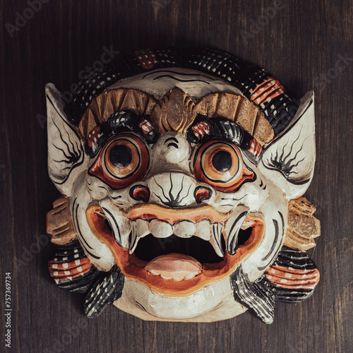 Asian ritual mask on a wooden wall background. Closeup