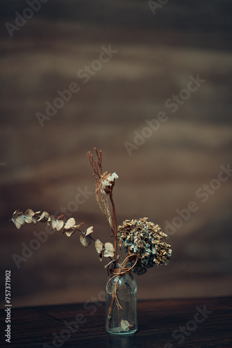 Close up and selective focus dry flowers in vase on wooden table in dining room or restaurant,still life concept.