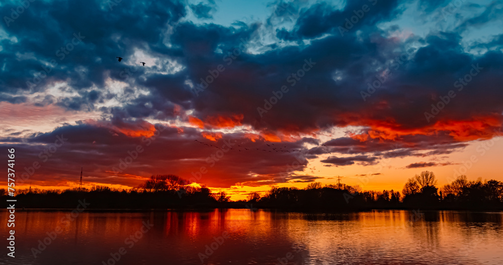 Naklejka premium Summer sunset with reflections near Plattling, Isar, Bavaria, Germany