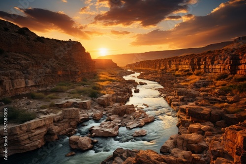 Sun sets on river in canyon with water, rocks, and cumulus clouds