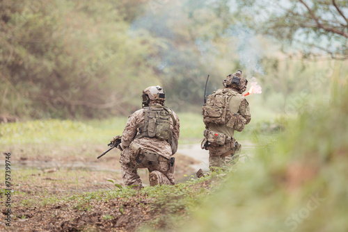 Soldiers in camouflage military uniforms carrying weapons, Reconnaissance missions in the tropical forest area, Assault infantry battle training.
