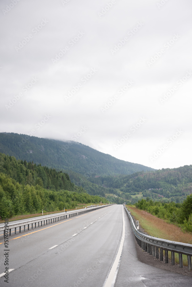 highway leading into the mountains and fjords of Norway on a foggy day. highway leading into the mountains and fjords of Norway on a foggy day.