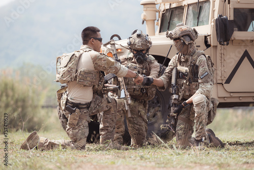 Wall Mural Group of soldiers in camouflage uniforms hold weapons in a jltv car, Plan and prepare for combat training