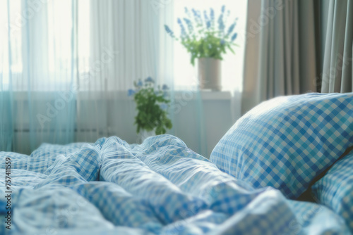 closeup of bed with blue and white checkered pillows and blanket