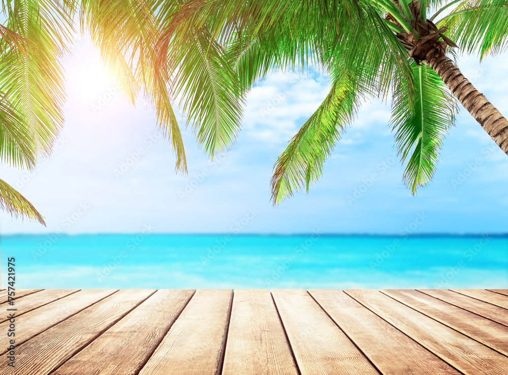 Old wooden table with turquoise water, coconut palm trees and blue sky background. Summer beach holiday concept. Old wooden table with turquoise water, coconut palm trees and blue sky background. Summer beach holiday concept.