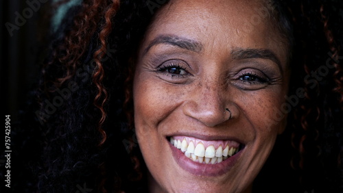 One happy middle-aged black woman close-up face smiling at camera. South American female person of African descent photo