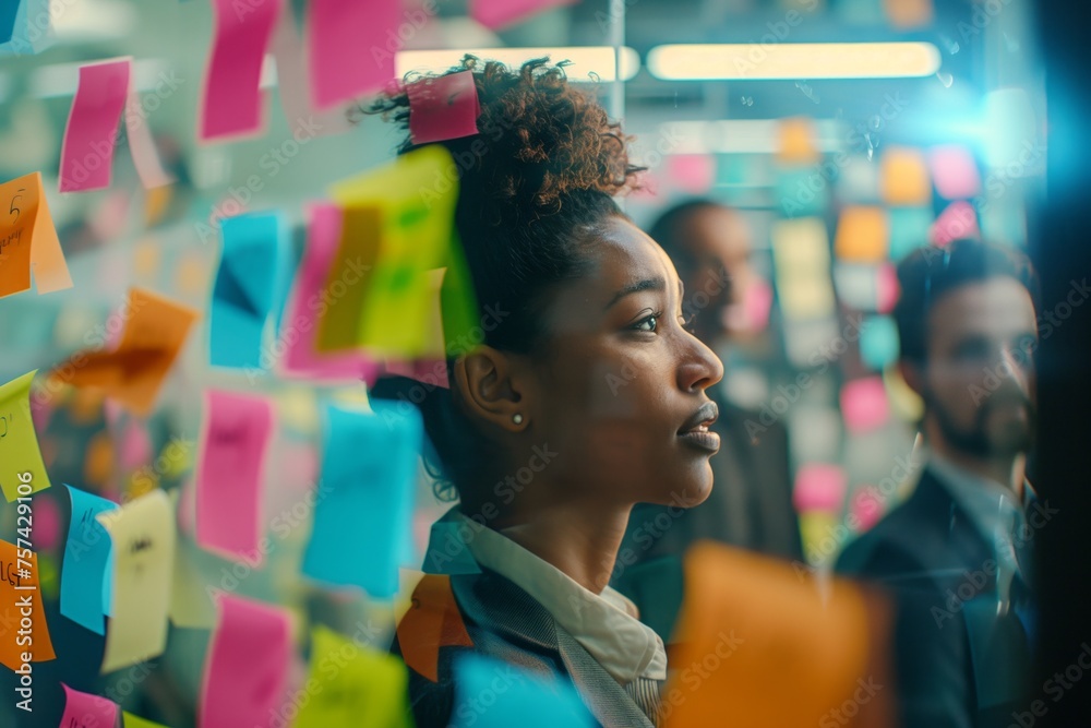 Fototapeta premium A woman is standing in front of a magenta wall covered in sticky notes, creating a fun and visually appealing art piece for a street art event