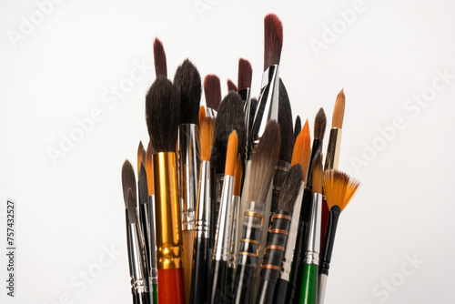 Mix of paint brushes in a row isolated on a white background. Top view.