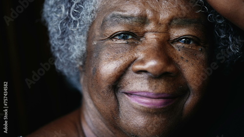 joyful South American elderly black lady in 80s depicting wisdom wrinkles in old age. Gray-hair Senior woman of African descent looking at camera smiling
