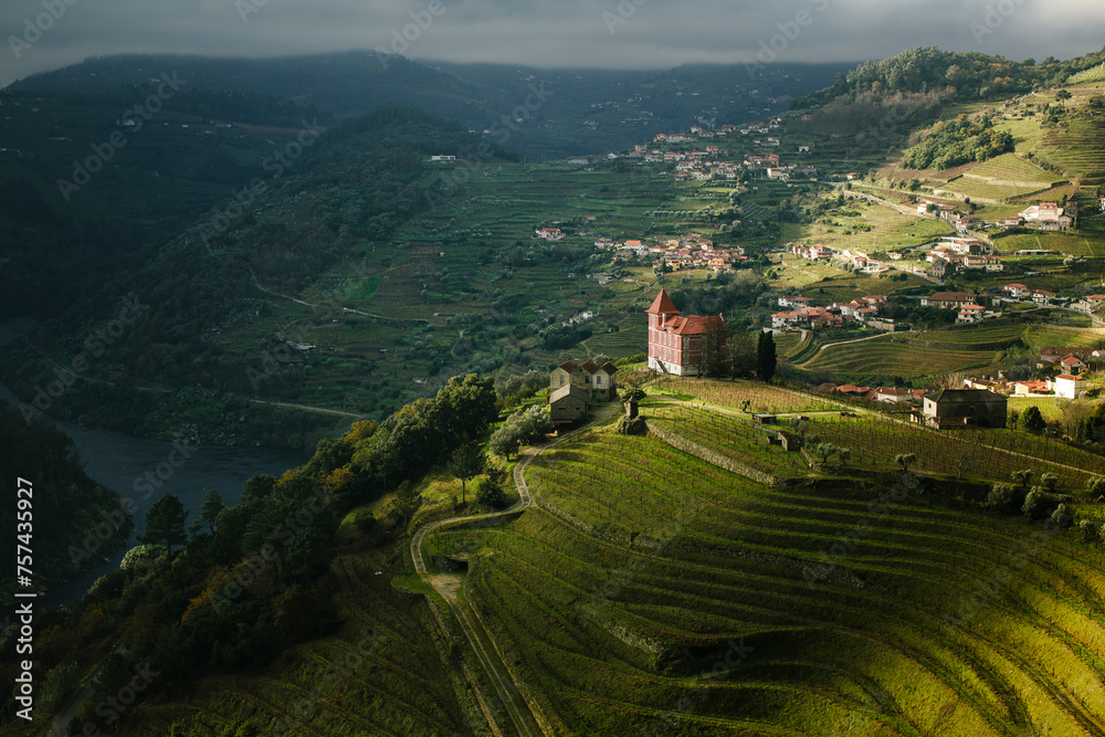 A view of a river and a village in the hills of the Douro Valley in northern Portugal. - obrazy, fototapety, plakaty 