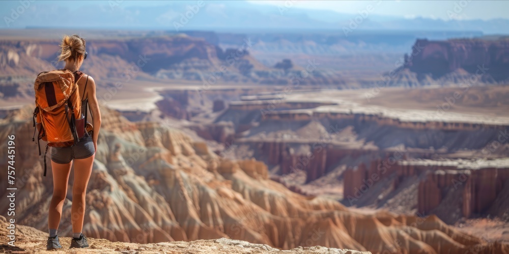 Woman hiker observing a vast desert landscape.