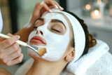 Beautiful woman having a facial mask at beauty salon
