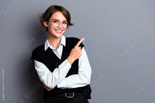 Photo of positive happy lady coach dressed black vest eyewear pointing finger empty space isolated grey color background