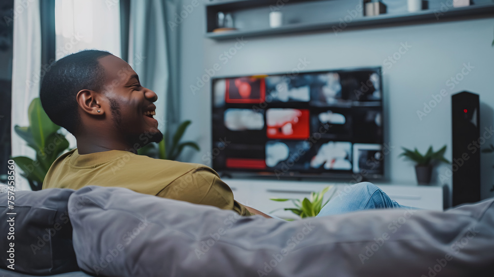 man sitting on the sofa in a living room watching television - copy space man sitting on the sofa in a living room watching television - copy space