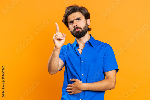Displeased upset middle eastern man reacting to unpleasant awful idea, dissatisfied with bad quality, wave hand, shake head No dismiss idea dont like proposal. Guy isolated on orange studio background photo