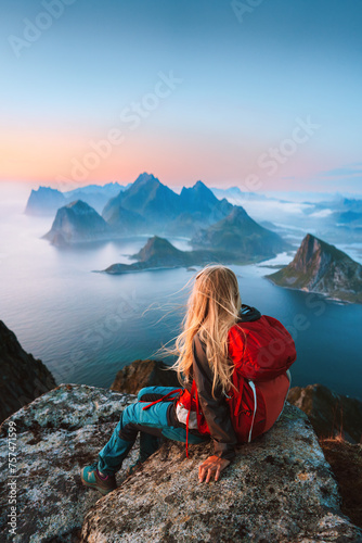 Woman traveler hiking in Norway girl backpacker relaxing on mountain cliff edge in Lofoten islands female tourist traveling outdoor alone healthy lifestyle summer vacations adventure trip