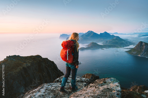 Woman hiking in Norway solo traveler on mountain cliff edge in Lofoten islands tourist with backpack traveling outdoor alone healthy lifestyle summer vacations adventure eco tourism