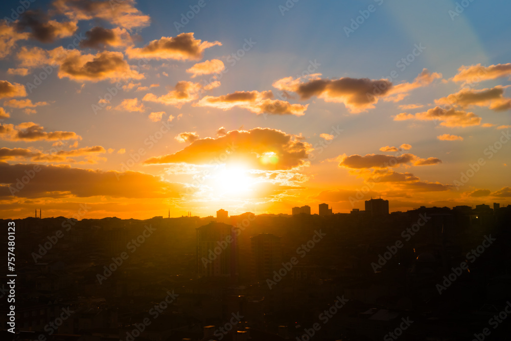 Colorful sunset sky with clouds and the setting sun over the city of Istanbul, Turkey in the evening - apartment, residential buildings silhouettes. Urban, cityscape, cloudscape and summer concept