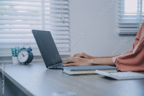 Young adult happy smiling Hispanic Asian student wearing headphones talking on online chat meeting using laptop in university campus or at virtual office. College female student learning remotely.