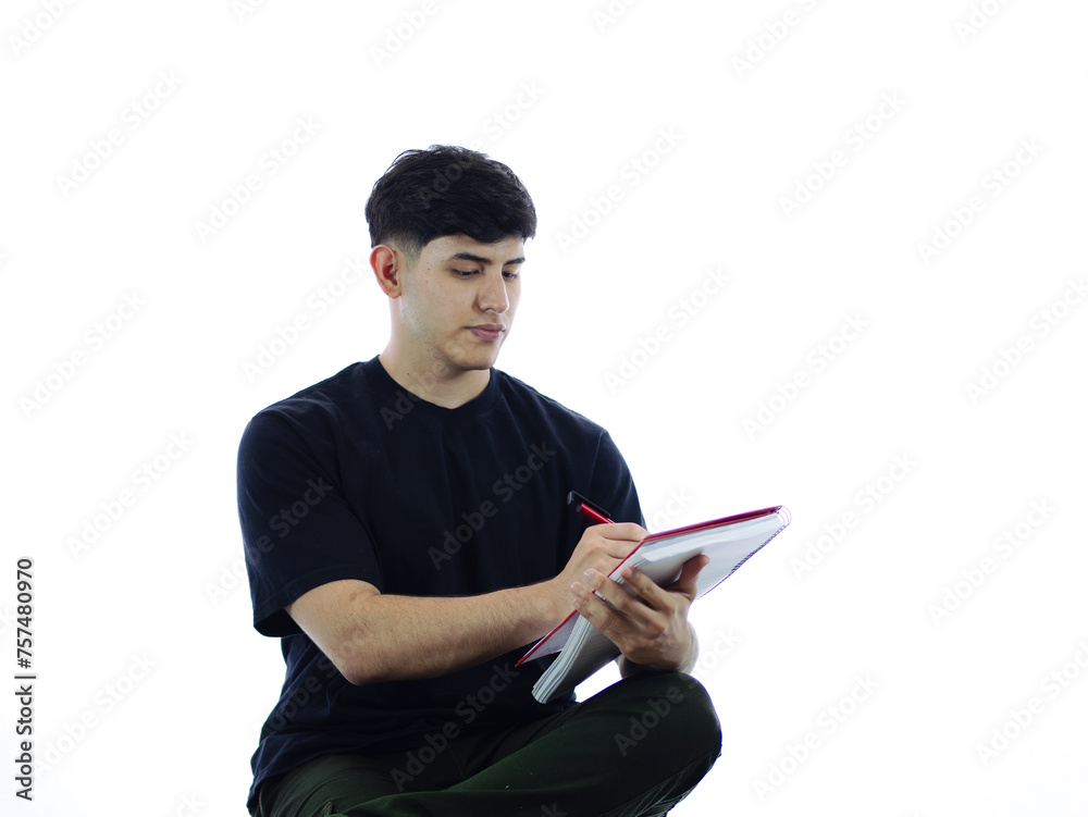 Image of a concentrated young man writing in a notebook, ideal for representing study, work or business concepts. White background for easy editing Image of a concentrated young man writing in a notebook, ideal for representing study, work or business concepts. White background for easy editing