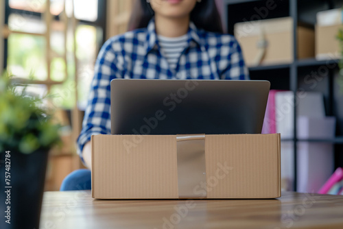 Business owner Start up of enterprise small using laptop at workplace small business entrepreneur SME or freelance working with a box at home deliver to customers, Online selling or e-commerce