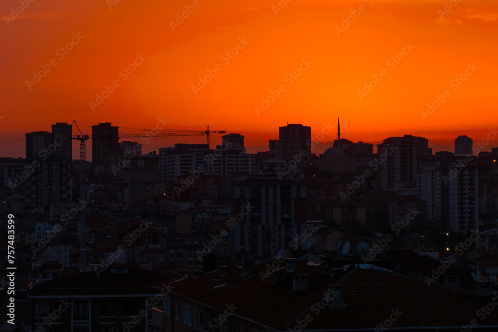View of amazing sky after sunset over the city of Istanbul, Turkey in the evening - cityscape with residential buildings silhouettes
