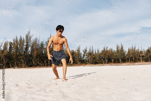 Muscular Asian Man Running on Beach: Active Lifestyle and Fitness