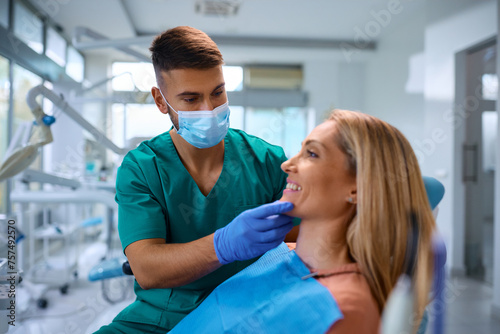 Dentist examining teeth of female patient at dentist s office.
