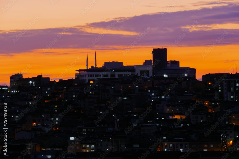 View of amazing sky after sunset with clouds over the city of Istanbul, Turkey in the evening - cityscape with residential buildings silhouettes