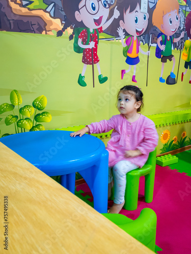 niña sentada en sala de juegos sola photo