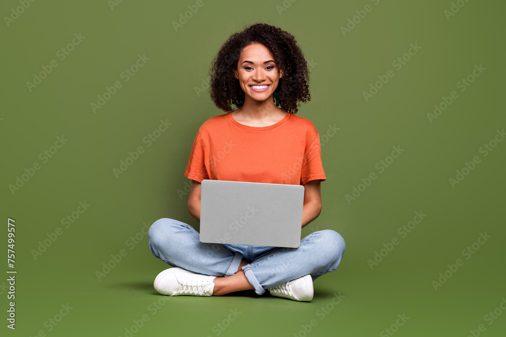 Full length photo of sweet cute lady dressed orange t-shirt communicating modern device isolated khaki color background Full length photo of sweet cute lady dressed orange t-shirt communicating modern device isolated khaki color background