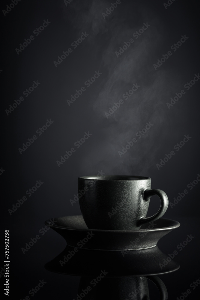 Black cup of coffee on a black reflective background. Black cup of coffee on a black reflective background.