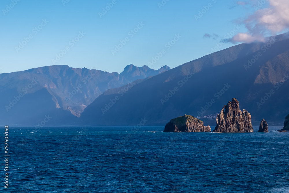 Panoramic view of volcanic rock formation Ilheus da Janela in coastal town Porto Moniz, Madeira island, Portugal, Europe. Rugged cliffs of coastline of majestic Atlantic Ocean. Massive mountain ridges Panoramic view of volcanic rock formation Ilheus da Janela in coastal town Porto Moniz, Madeira island, Portugal, Europe. Rugged cliffs of coastline of majestic Atlantic Ocean. Massive mountain ridges