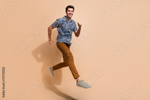 Profile full body photo of energetic motivated young man workaholic running to get promotion in career islated on beige color background