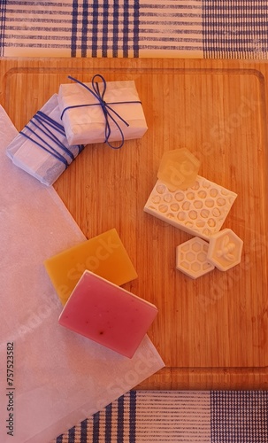 pastillas de jabón artesanos de varios tipos y envuelto con un lazo azul sobre una tabla de madera