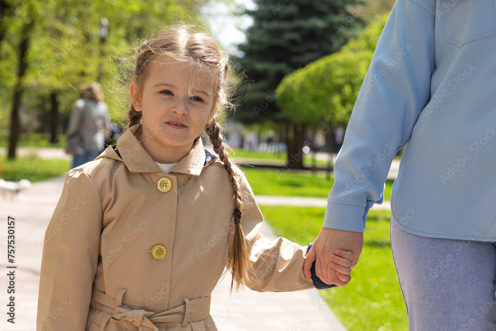 Close-up portrait of a cute beautiful little girl holding her mother's hand. Lovely family spring or summer photo outdoors Close-up portrait of a cute beautiful little girl holding her mother's hand. Lovely family spring or summer photo outdoors