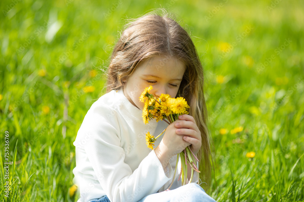 Portrait of a cute smiling little girl on green grass with dandelions Portrait of a cute smiling little girl on green grass with dandelions