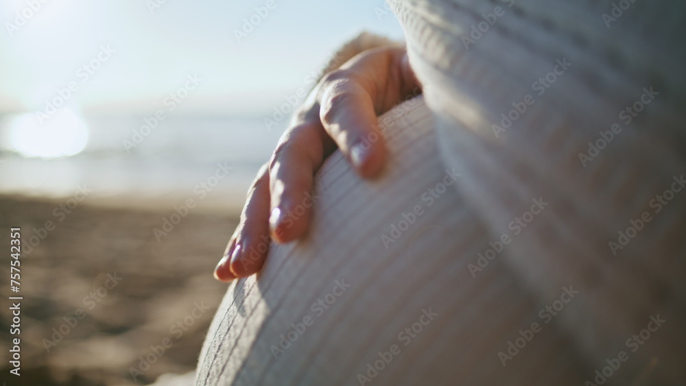 Woman hand caressing belly expecting baby close up. Pregnant tummy at sunset