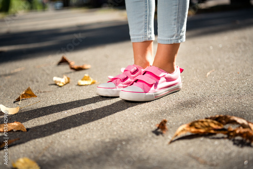 Cropped photo of cute little girl legs dressed pink sneakers walking ground enjoy good weather outdoors urban city park